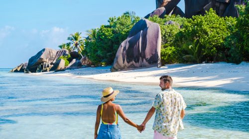 Anse Source d'Argent, La Digue Seychelles, a young couple of Caucasian men and Asian women on a tropical beach during a luxury vacation in Anse Source d'Argent, La Digue Seychelles