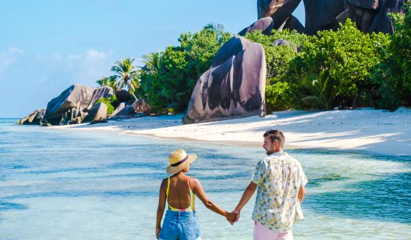 Anse Source d'Argent, La Digue Seychelles, a young couple of Caucasian men and Asian women on a tropical beach during a luxury vacation in Anse Source d'Argent, La Digue Seychelles