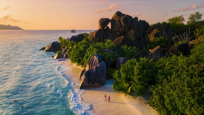 Anse Source d'Argent, La Digue Seychelles, a young couple of Caucasian men and Asian women on a tropical beach during a luxury vacation in Anse Source d'Argent, La Digue Seychelles